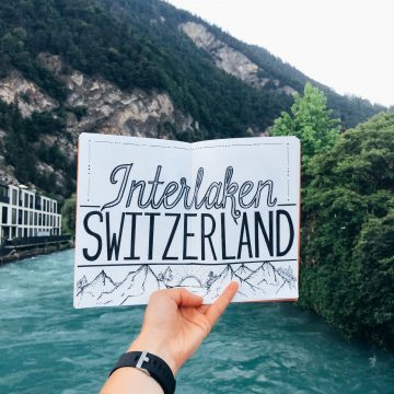 Interlaken Switzerland Lettering on white sheet of paper with scenic river in background