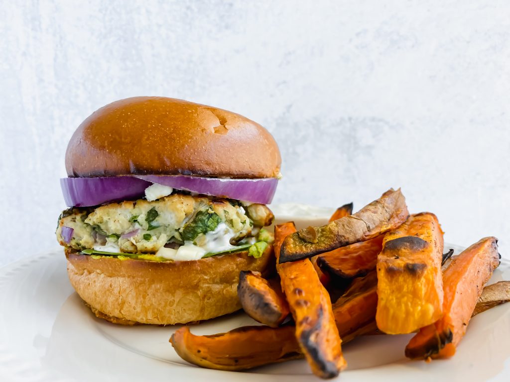 front shot of spinach ranch feta turkey burgers on a plate with sweet potato fries