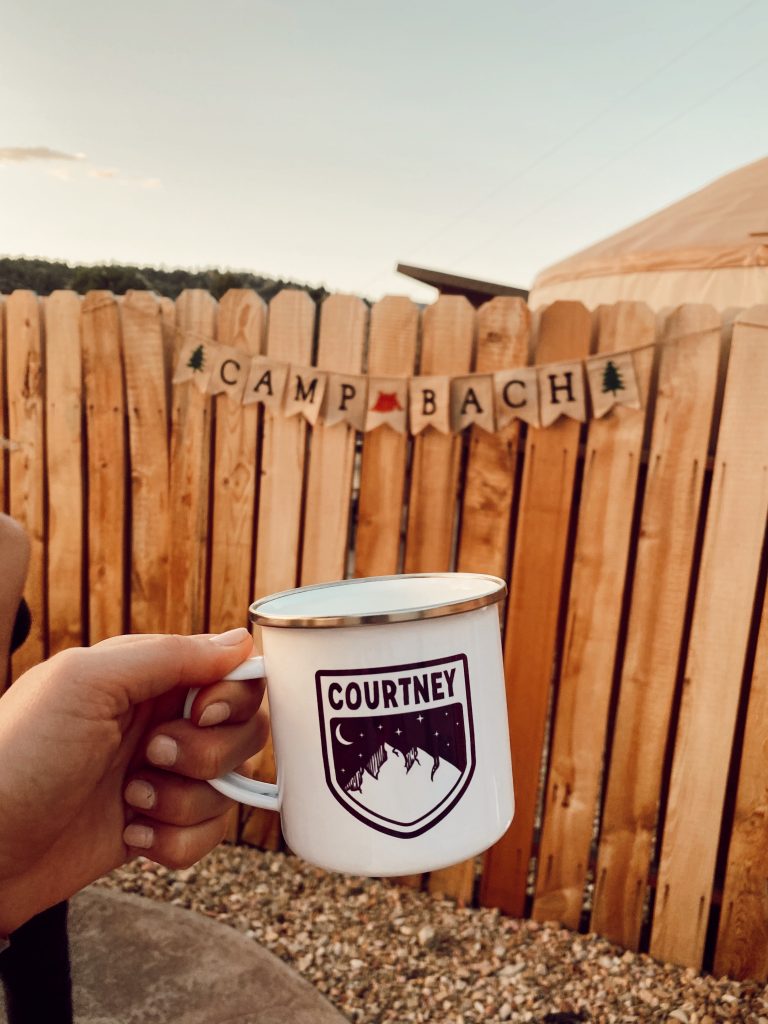 campfire mug that says courtney with wooden fence behind it