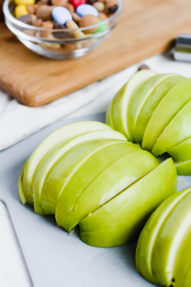 green apple sliced finely on a grey cutting board