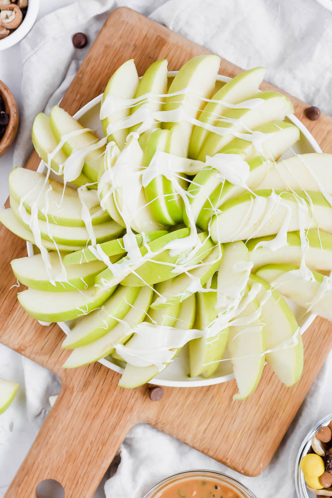 white chocolate drizzled on top of green apples