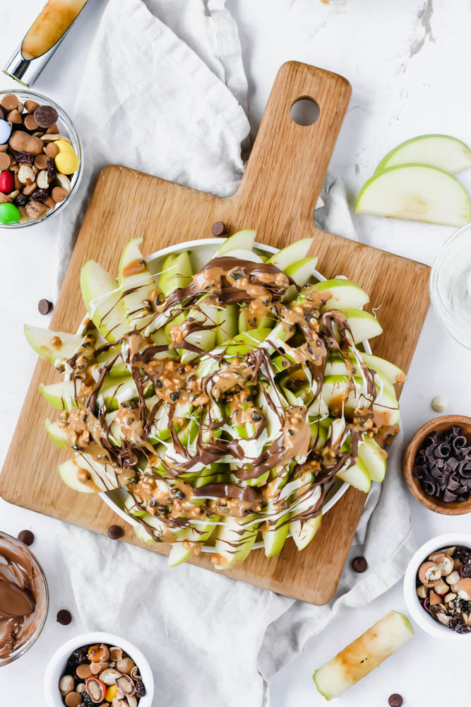peanut butter drizzled on top of green apples
