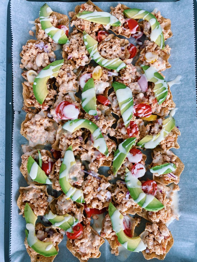 Flat lay image of sheet pan nachos with drizzled quest