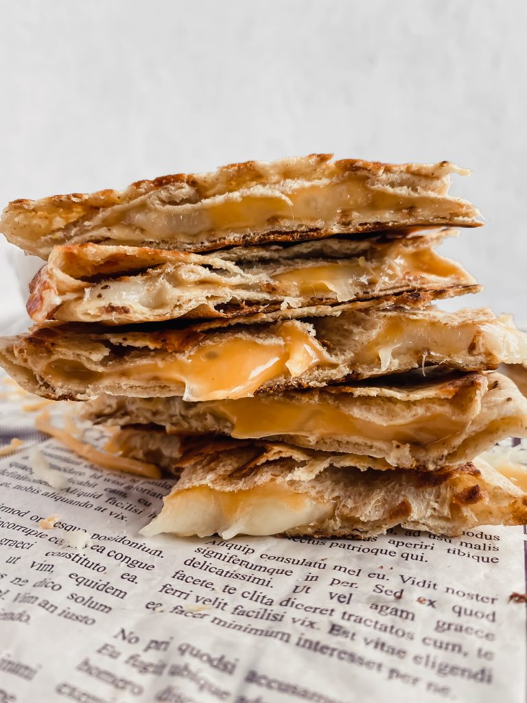 Macro-friendly cheesy quesadilla slices are stacked on top of one another.