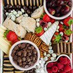 overhead image of fully assembled charcuterie board with lots of fresh berries and chocolate
