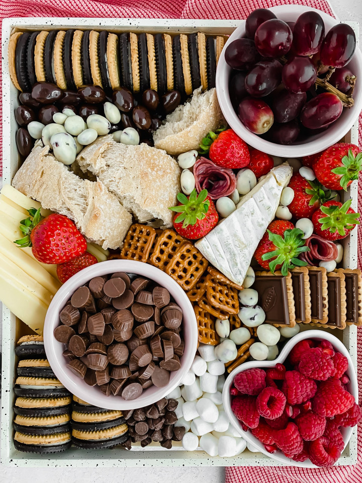 fully assembled dessert charcuterie board with fresh fruit, chocolate, cookies, and candies.