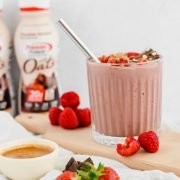 fruit smoothie topped with chocolate and nut butter and brand in the background