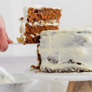 Cutting a slice of carrot cake with cream cheese frosting