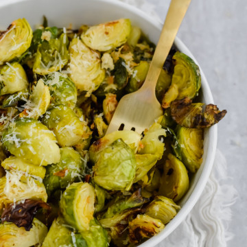 Bowl of Crispy Parmesan Brussels Sprouts with a gold fork