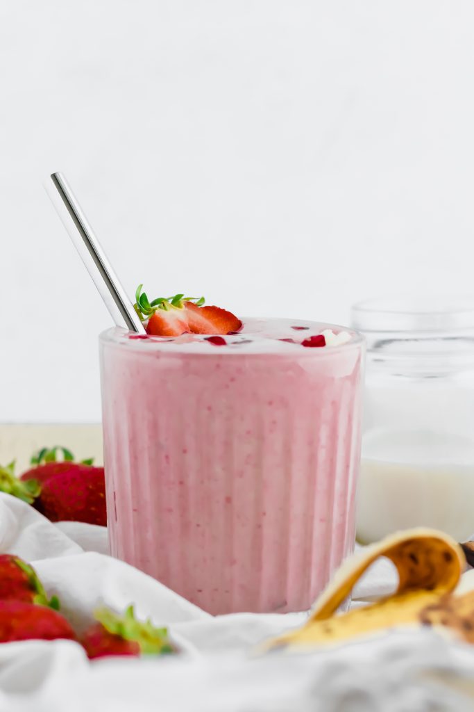 Strawberry Banana Protein Smoothie in ribbed glass with a metal straw