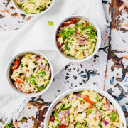 4 bowls of Orzo Pasta Salad with textured tiled background and white napkin