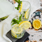 Two glasses garnished with mint leaves and lemon slices