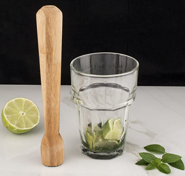 wooden drink muddler with glass and lime