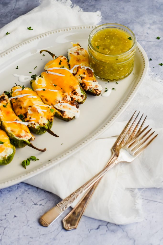 cheesy jalapeno poppers topped with salsa verde and mexican crema