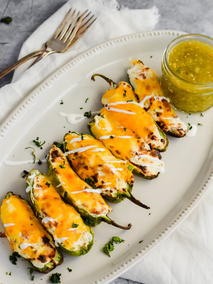tray of air fried easy jalapeno poppers topped with melted cheese and salsa verde.