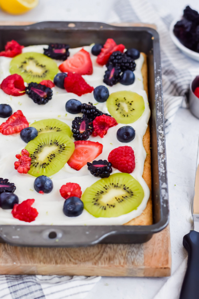baked fruit pizza topped with frosting and fruit