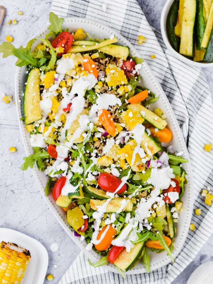 grilled veggie salad fully assembled with dressing drizzled on top.
