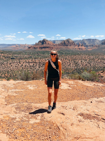 girl in hiking gear standing in front of backdrop of Sedona