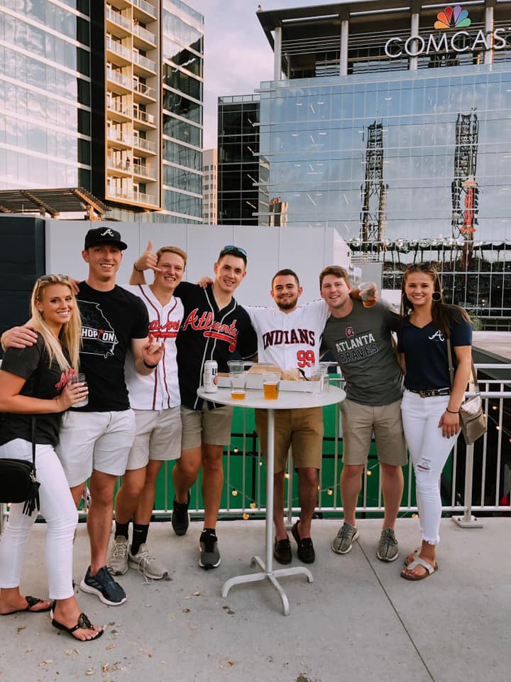 group of friends huddled around a cocktail table at Atlanta Braves Game