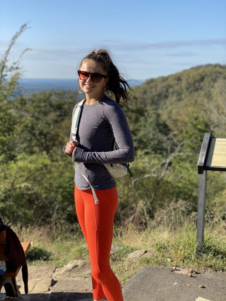 girl in athletic wear hiking to the top of kennesaw mountain and smiling