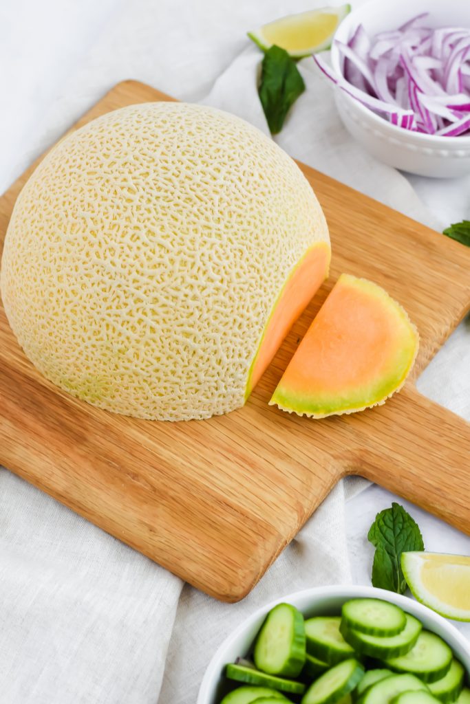 half of a cantaloupe with end sliced off prior to cutting