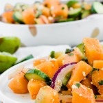 90 degree angled image of cantaloupe salad served on white dish with main serving bowl in the background