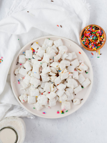 funfetti puppy chow plated on a dish with concrete background