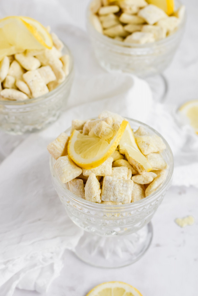 three glasses of lemon puppy chow topped with slices of lemon