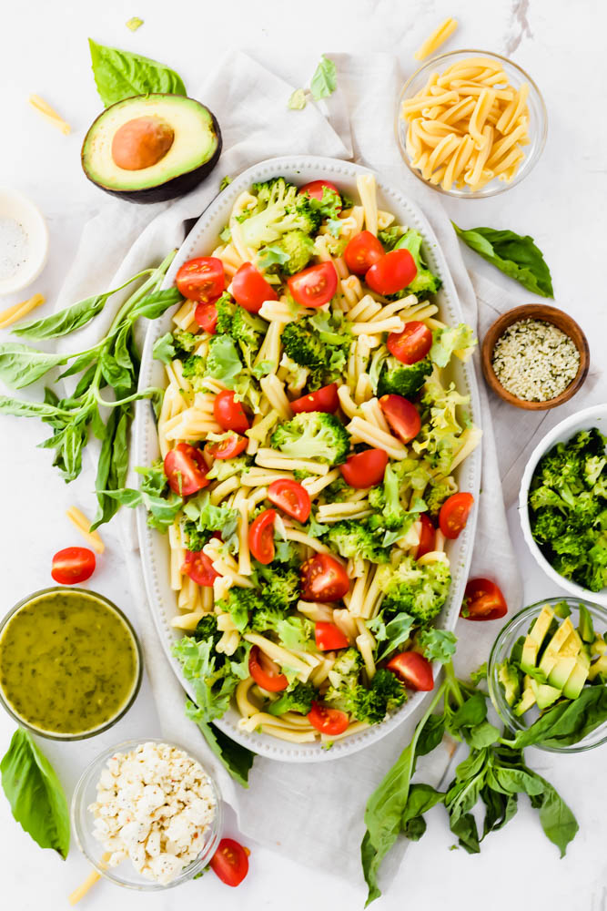 large pasta salad plate filled with vegetables and surrounded by garnishings