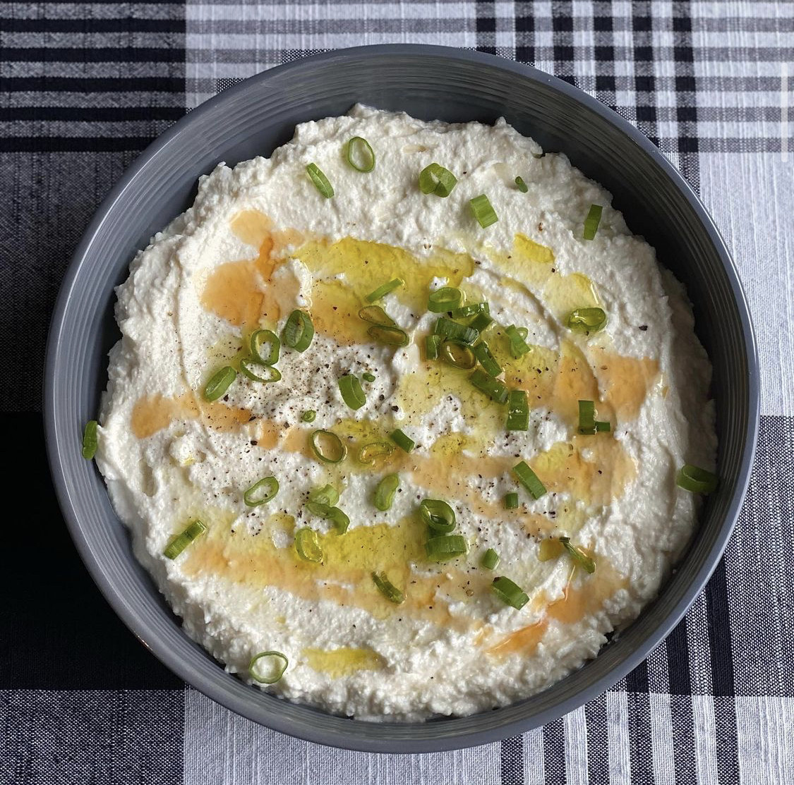 grey bowl filled with whipped feta dip topped with honey and scallions