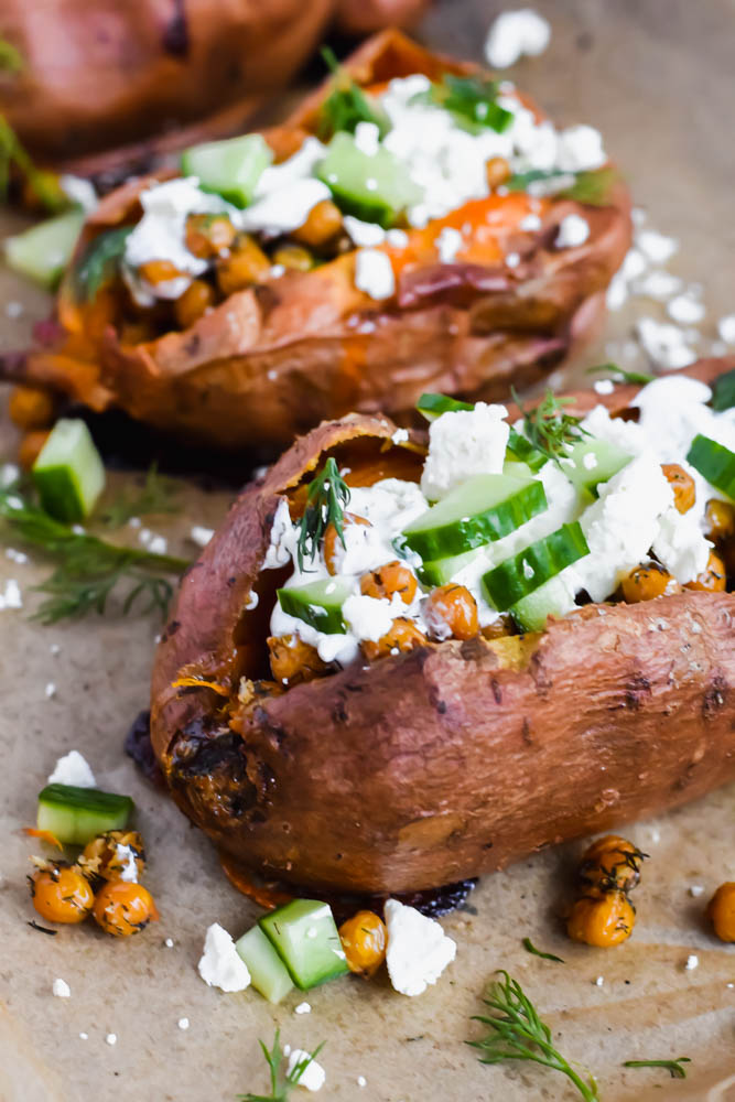 close up of baked sweet potato topped with cucumber, roasted chickpeas and tzatziki sauce