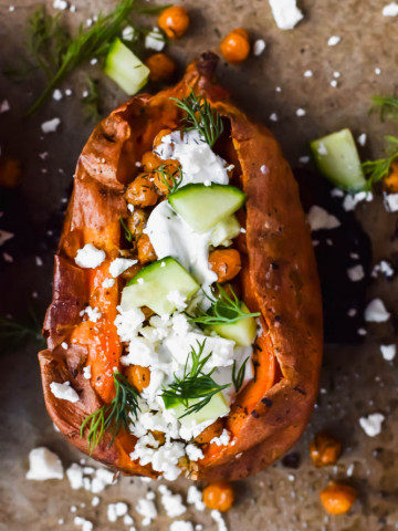 oven roasted sweet potato garnished with cucumbers, fresh dill, tzatiki sauce and feta cheese