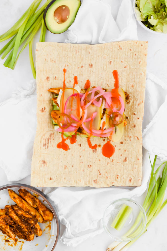 add pickled onions and buffalo sauce to the buffalo chicken wrap