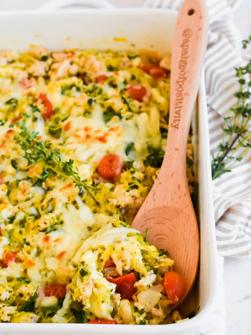 Large white baking dish with spaghetti squash feta cheese casserole recipe with wooden spoon in dish.