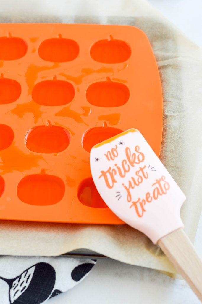 halloween themed rubber spatula filled with orange pumpkin jello gummies ready to harded