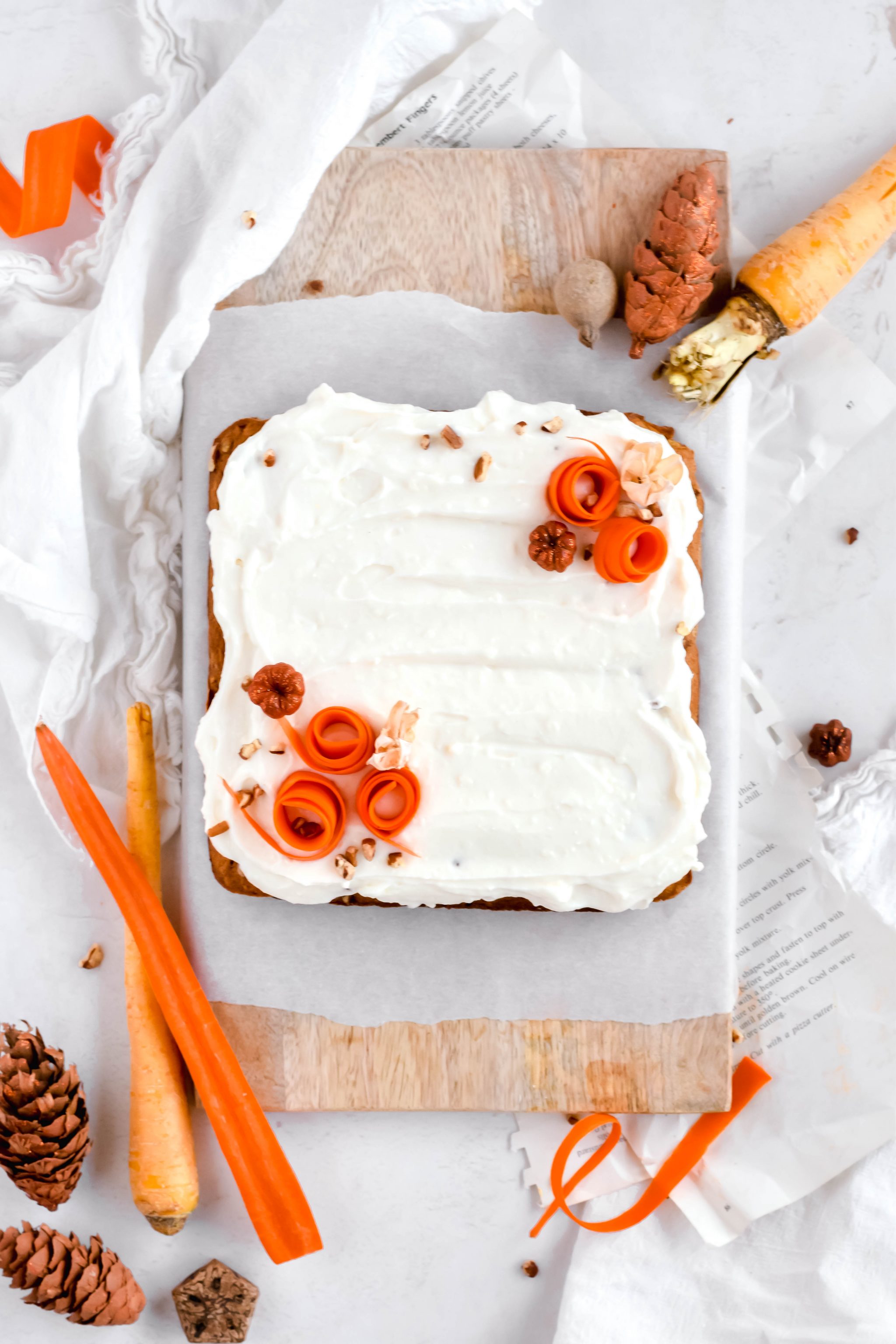 Overhead view of carrot cake bars with cream cheese icing topped with shredded carrots
