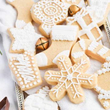 Overhead view of Shortbread Christmas Cookies with Icing on a silver tray with white linen