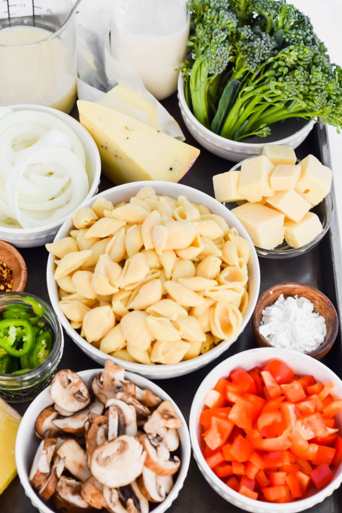 ingredients to make gouda mac and cheese in small bowls on sheet pan