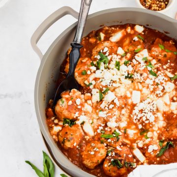 Zesty Turkey Meatballs in a gray skillet with a serving spoon