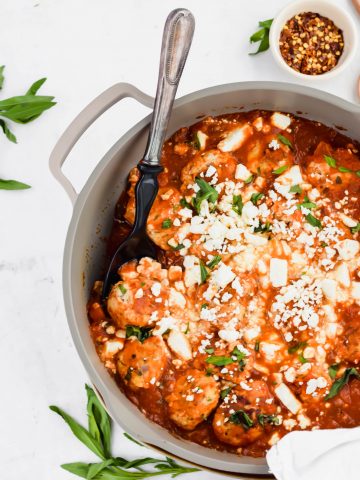 Zesty Turkey Meatballs in a gray skillet with a serving spoon