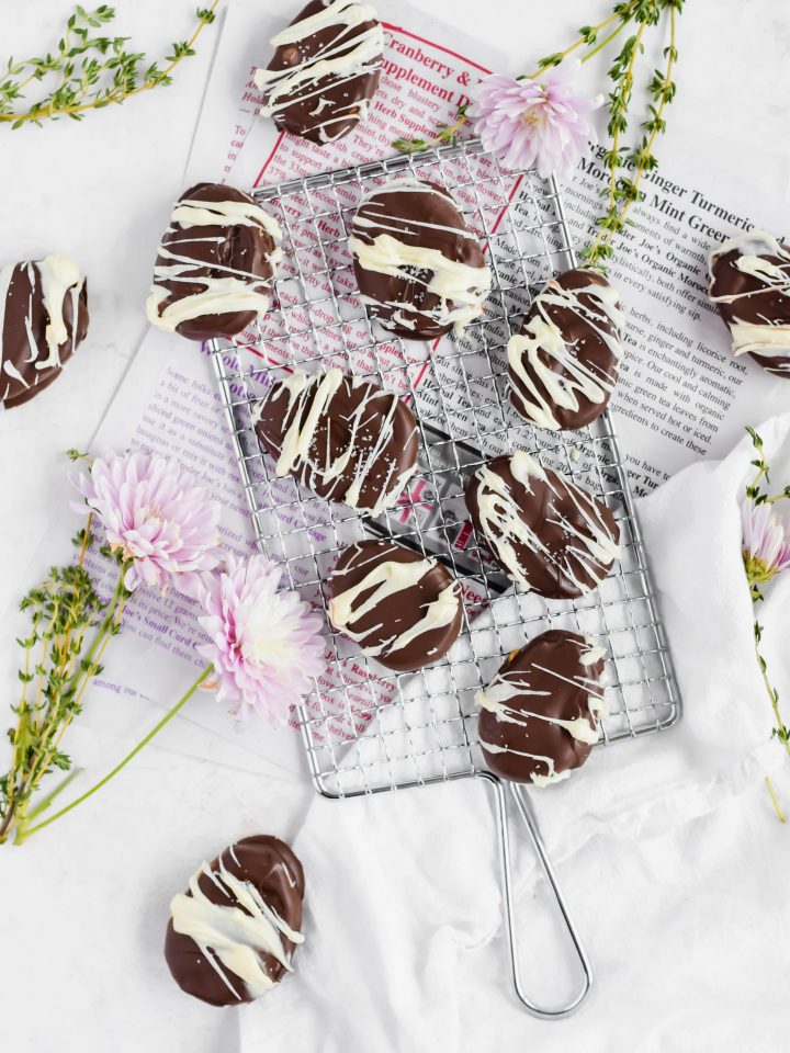 Homemade Peanut Butter Eggs drizzled with white chocolate on a metal wire serving tray.