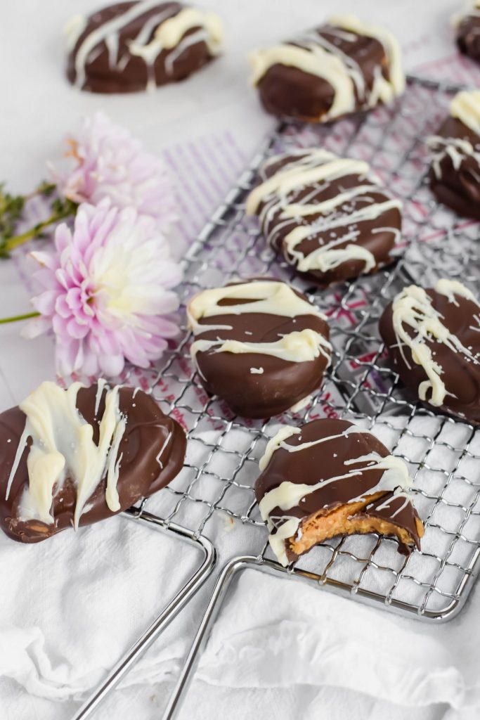 Copycat Reese's Easter Eggs drizzled with white chocolate on a metal wire serving tray