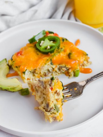 Forkful of High Protein Breakfast Frittata on a white plate with sliced avocado