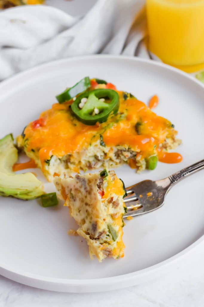Forkful of High Protein Breakfast Frittata on a white plate with sliced avocado