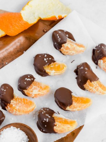 Chocolate covered oranges sprinkled with sea salt on parchment paper
