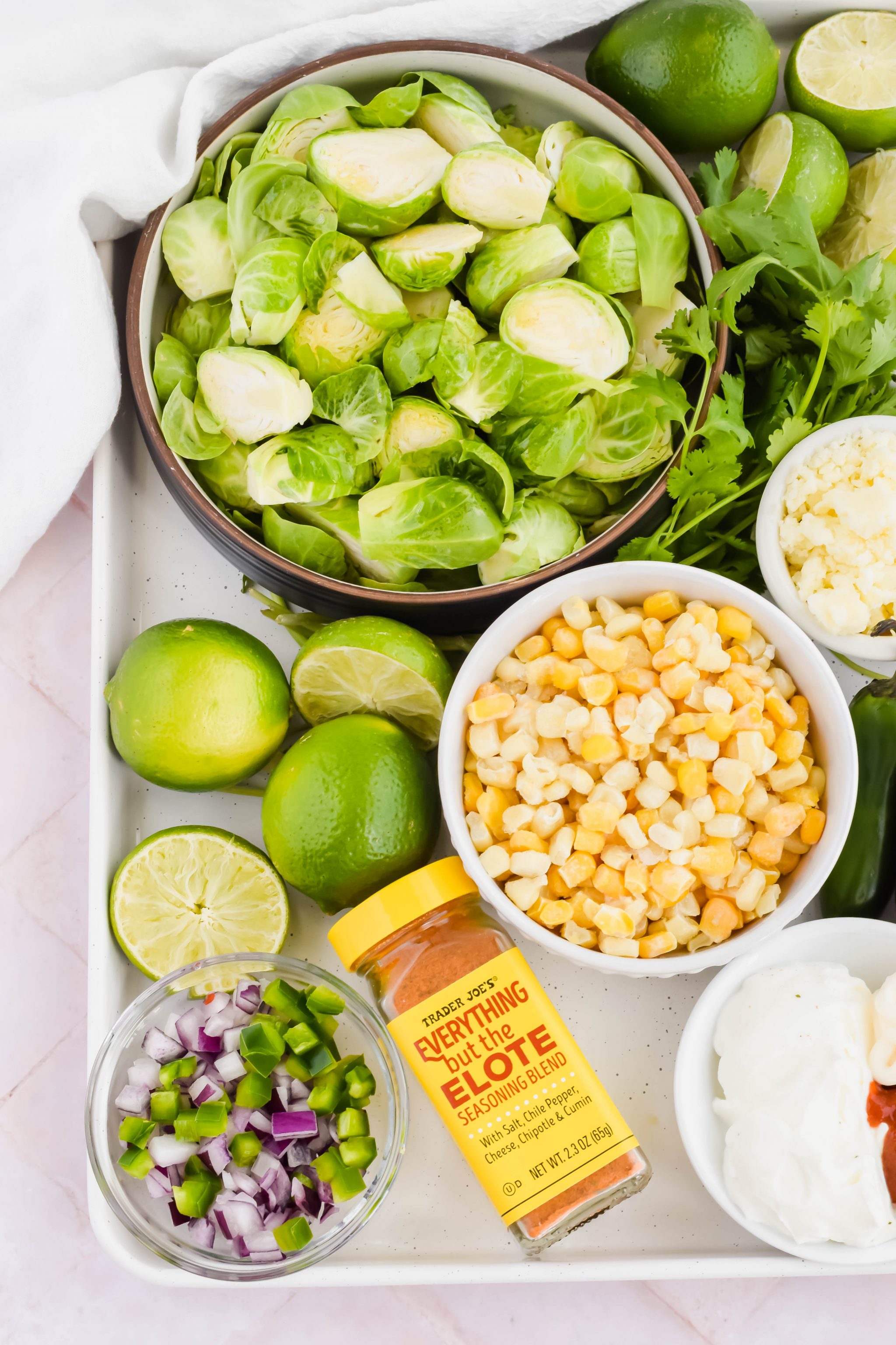 Street corn mexican brussel sprout recipe ingredients on white baking sheet.
