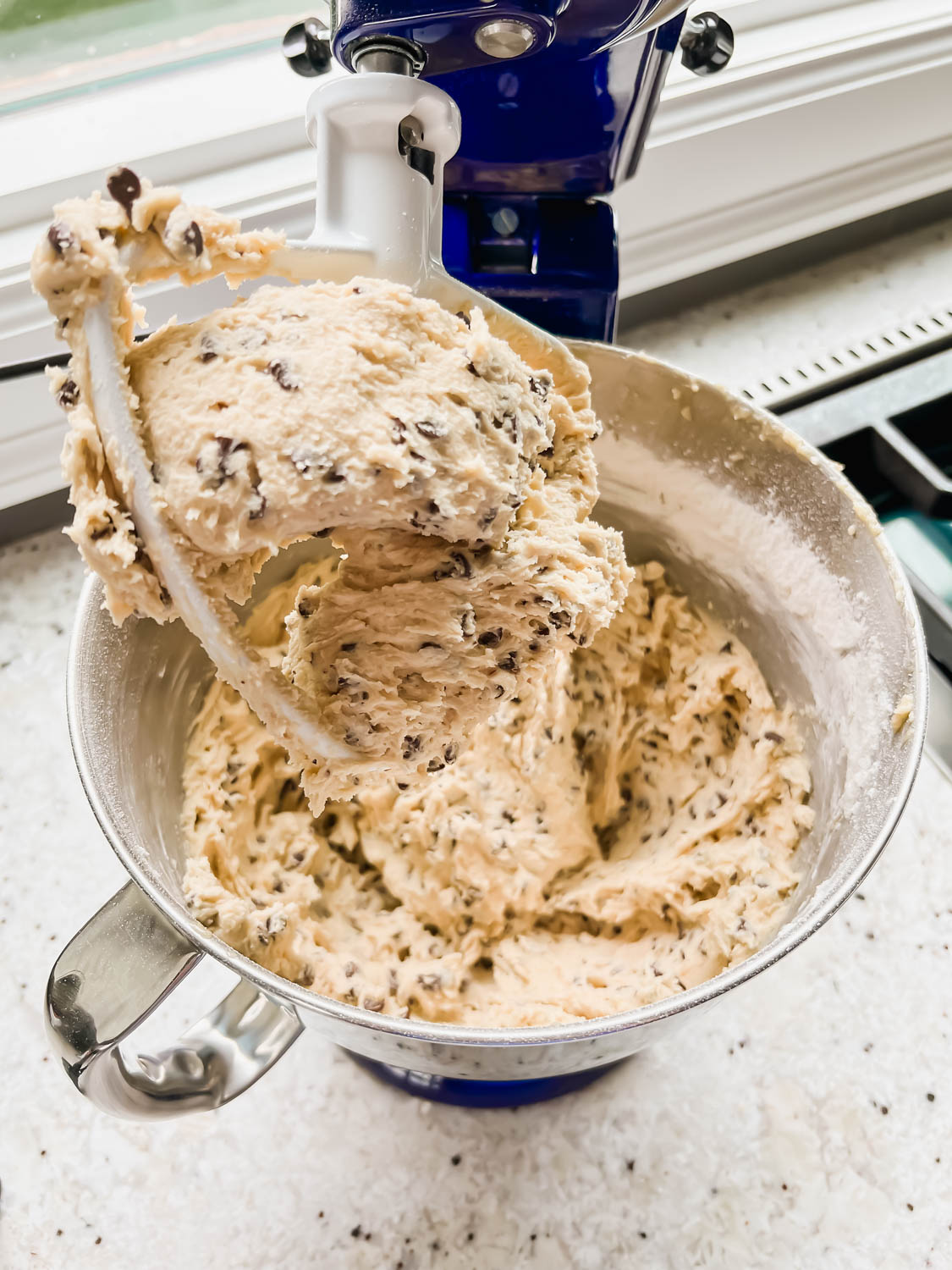 mixed chocolate chip cookie dough in silver stand mixer bowl.