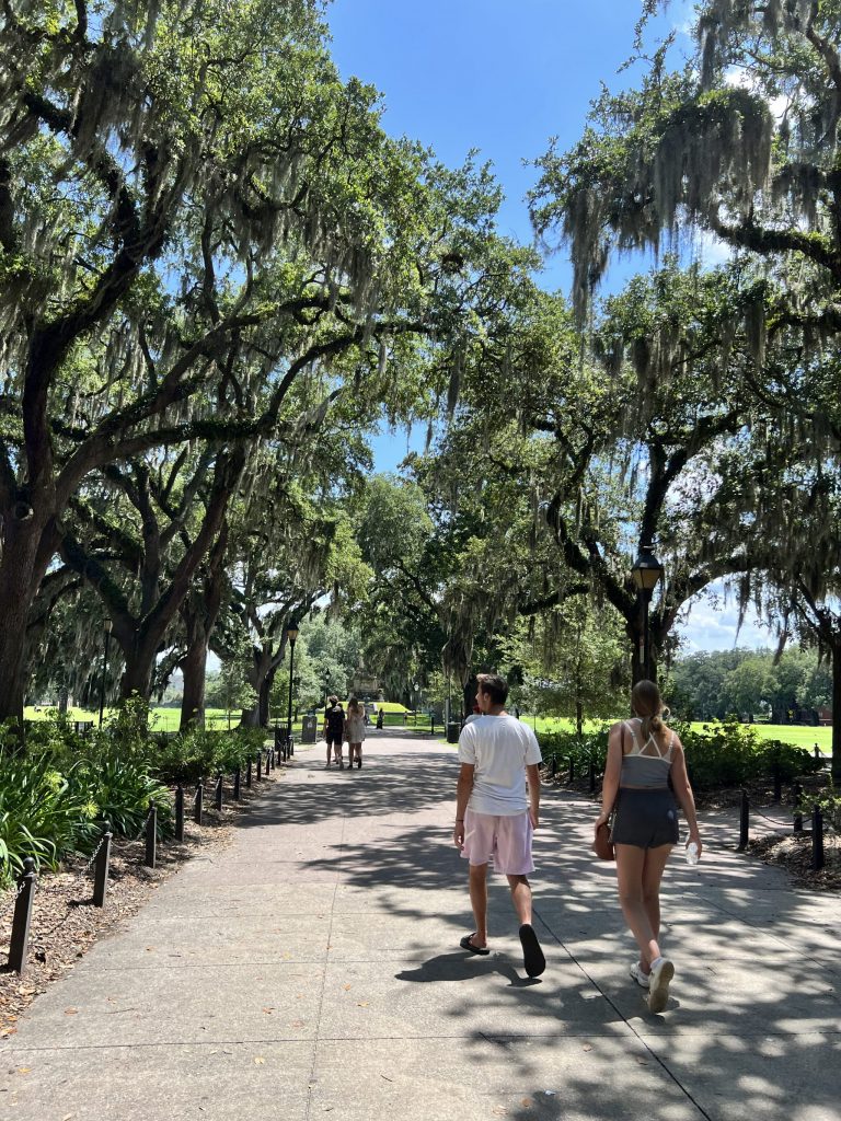 scenic view of Forsyth Park with a couple walking on the sidewalk