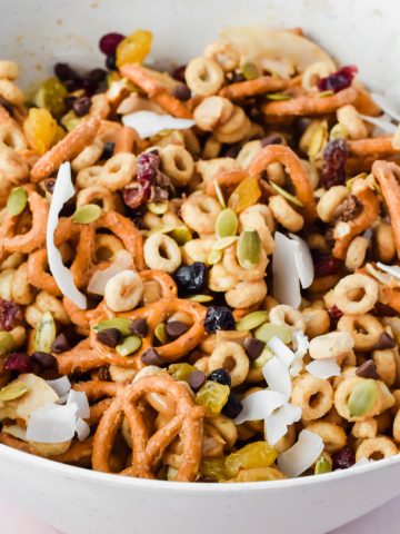 cheerio trail mix mixed in large white bowl.