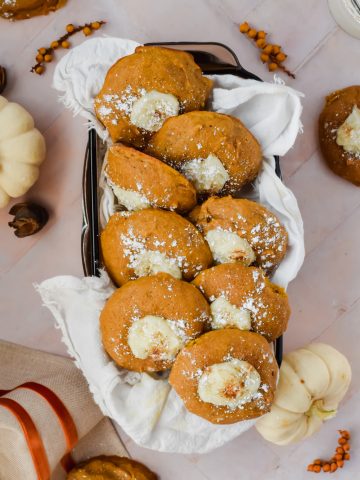 overhead shot of 8 pumpkin cheesecake cookies in rectangular dish surrounded by fall decor.